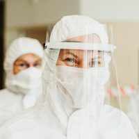 审校人员在纸质稿件上做批注，旁边放着一支红笔与一杯茶，体现内容复核场景